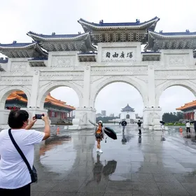 سائحون يلتقطون صوراً أمام "ساحة الحرية" مع اقتراب الإعصار فونج-وونج من اليابسة، تايبيه، تايوان. 11 نوفمبر 2025 - Reuters