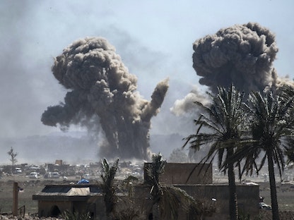 دخان يتصاعد فوق موقع لتنظيم "داعش" في بلدة الباغوز، بدير الزور شرقي سوريا، بعد قصف جوي - 18 مارس 2019 - AFP