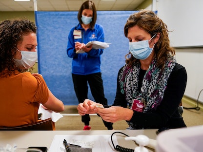 عاملات في قطاع الصحة بولاية إنديانا الأميركية خلال الاستعدادات لحملات التطعيم بلقاح كورونا - REUTERS