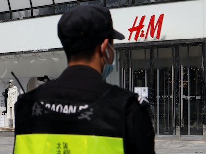 رجل أمن يقف أمام أحد فروع متجر "إتش آند إم" لبيع الملابس بالتجزئة في بكين - REUTERS