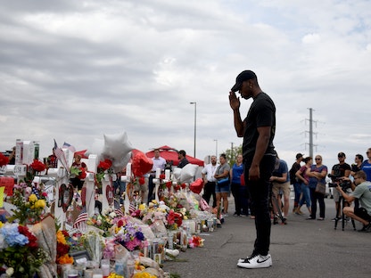 رجل يقف أمام نصب تذكاري في محيط مكان إطلاق النار قرب متجر وول مارت في إل باسو بتكساس - 6 أغسطس 2019 - REUTERS