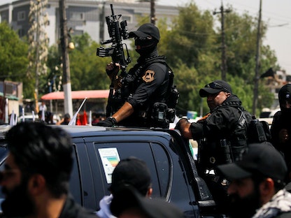 عناصر من الحشد الشعبي خلال تشييع بعض أعضاء الحشد ممن قتلوا في غارة أميركية على الحدود السورية العراقية، بغداد، 26 يونيو 2021 - REUTERS