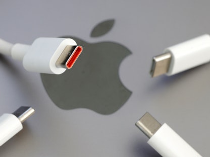 أسلاك USB-C وفي الخلفية شعار شركة أبل - REUTERS