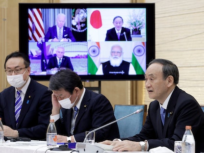 رئيس الوزراء الياباني يوشيهيدي سوغا يتحدث أثناء قمة افتراضية لقادة دول مجموعة "كواد"، وبدا على الشاشة رئيس الوزراء الهندي ناريندرا مودي والرئيس الأميركي جو بايدن ورئيس الوزراء الأسترالي سكوت موريسون - 12 مارس 2021 - REUTERS