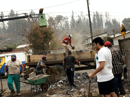سكان محليون يتفقدون بقايا منازل محترقة بعد حريق هائل في بيورين بالقرب من تيموكو في تشيلي. 4 فبراير 2023 - REUTERS