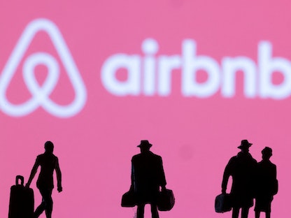 مسافرون أمام شعار Airbnb في رسم توضيحي - 27 فبراير 2022 - REUTERS