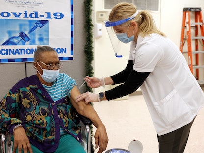 عجوز أميركية تتلقى اللقاح المضاد لفيروس كورونا في مدينة نيويورك - 12 مايو 2022 - REUTERS