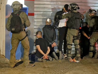القوات الإسرائيلية تحتجز مجموعة من الشبان العرب خلال احتجاجات في مدينة اللد - 13 مايو 2021 - AFP