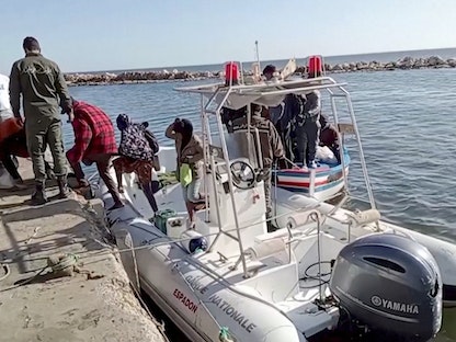 عناصر من خفر السواحل التونسي يساعدون مهاجرين على النزول من قارب إنقاذ في مدينة جبنيانة بولاية صفاقس. 23 أبريل 2022 - REUTERS