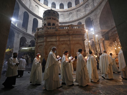 الرهبان الفرنسيسكان في موكب خلال قداس بكنيسة القيامة في القدس، في 1 أبريل 2021.  - AFP