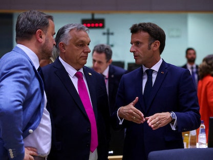 الرئيس الفرنسي إيمانويل ماكرون يتحدث إلى رئيس الوزراء المجري فيكتور أوربان على هامش قمة قادة الاتحاد الأوروبي في بروكسل، بلجيكا- 30 مايو 2022. - REUTERS