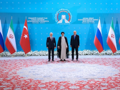 الرئيس الإيراني إبراهيم رئيسي يتوسط نظيريه التركي رجب طيب أردوغان والروسي فلاديمير بوتين خلال قمة ثلاثية في طهران - 19 يوليو 2022 - REUTERS