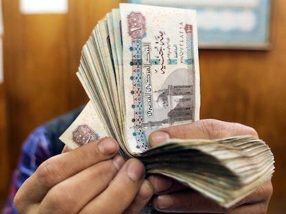 موظف يعد أوراقاً نقدية من فئة الـ100 جنيه مصري في مكتب بوسط القاهرة - 29 مارس 2019 - REUTERS