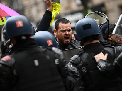 الشرطة الفرنسية في مواجهة متظاهرين ضد مشروع قانون "الأمن الشامل" في العاصمة الفرنسية باريس - 30 يناير 2021  - AFP