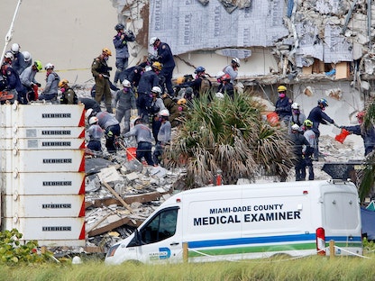 عمال الطوارئ يقومون بجهود البحث والإنقاذ في موقع المبنى المنهار جزئياً في ميامي بولاية فلوريدا الأميركية - REUTERS