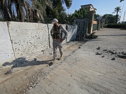 عنصر من قوات الأمن العراقية يتفقد الأضرار، بعد سقوط قذيفة صاروخية على المنطقة الخضراء بالقرب من السفارة الأميركية - 18 نوفمبر 2020  - AFP