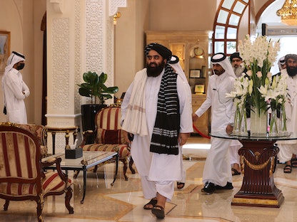 وزير الخارجية الأفغاني أمير خان متقي (وسط) يصل إلى اجتماع مع دبلوماسيين أجانب في العاصمة القطرية الدوحة، 12 أكتوبر 2021 - AFP