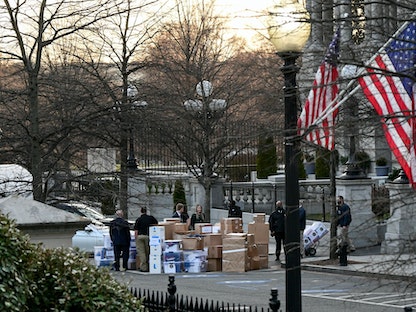 موظفون ينقلون صناديق ملفات من مبنى أيزنهاور التنفيذي المجاور للبيت الأبيض قبل مغادرة الرئيس المنتهية ولايته دونالد ترمب – واشنطن – 14 يناير 2021 - REUTERS
