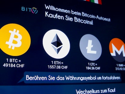 شعارات العملات الافتراضية على إحدى الشاشات في زويريخ - REUTERS