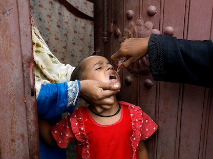 فتاة تتلقى قطرات لقاح شلل الأطفال، خلال حملة لمكافحة المرض، مع استمرار انتشار كورونا، في كراتشي، باكستان. 20 يوليو 2020. - REUTERS