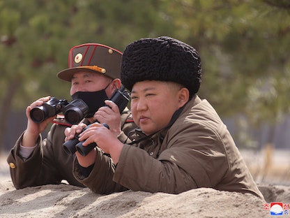 الزعيم الكوري الشمالي كيم جونغ أون يتابع حدثاً غير محدد الوقت والتفاصيل ممسكاً بمنظار مقرب - REUTERS