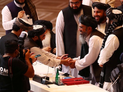 مندوبو طالبان يتصافحون خلال محادثات سابقة بين الحكومة الأفغانية ومتمردي طالبان في الدوحة - REUTERS