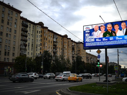 شاشة تعرض ملصقاً لحملة حزب روسيا الموحدة يضم مرشحين لمجلس الدوما من بينهم وزير الخارجية سيرجي لافروف، موسكو، 8 سبتمبر 2021 - AFP