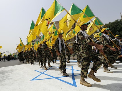 عناصر من "حزب الله العراقي" خلال عرض عسكري في بغداد بمناسبة "يوم القدس" - 25 يوليو 2014 - REUTERS