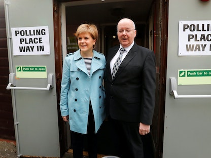 نيكولا ستورجن رئيسة الحكومة الاسكتلندية السابقة وزوجها بيتر موريل خلال التصويت بالانتخابات في جلاسكو. 4 مايو 2017 - REUTERS