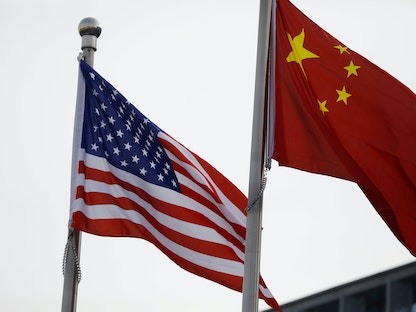علمان، صيني وأميركي، يرفرفان خارج مبنى شركة أميركية في بكين، 21 يناير 2021 - REUTERS
