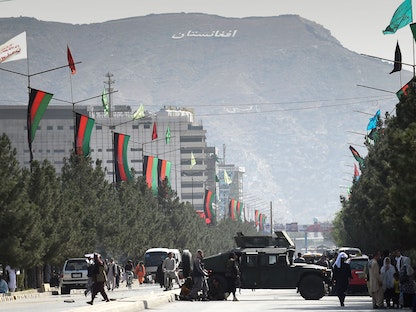 مقاتلو طالبان يغلقون طريقاً بسيارة عسكرية مدرعة بالقرب من مطار كابول، 28 أغسطس 2021 - AFP