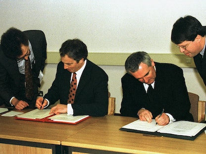 رئيسا الوزراء البريطاني توني بلير والإيرلندي وبيرتي أهيرن يوقعان اتفاقية السلام. 10 أبريل 1998 - REUTERS
