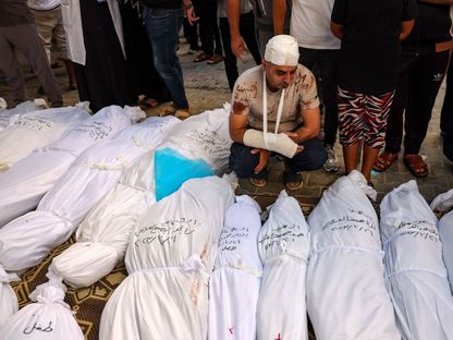 فلسطيني بين جثث مجموعة من أقاربه ممن قتلتهم غارات إسرائيلية على مدينة رفح بقطاع غزة في فلسطين. 21 أكتوبر 2023 - AFP
