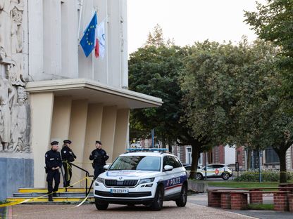 ضباط شرطة يقفون عند مدخل مدرسة جامبيتا الثانوية في منطقة أراس شمال شرق فرنسا بعد يوم من قتل مدرس في هجوم بسكين. 14 أكتوبر 2023 - AFP