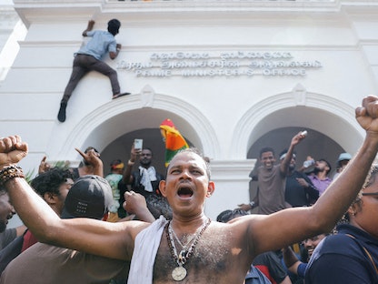 متظاهرون يحتفلون بعد اقتحام مكتب رئيس الوزراء رانيل ويكريميسنج في العاصمة كولومبو- 13 يوليو 2022 - REUTERS