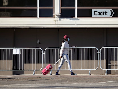 مسافرة تجر حقيبتها خارج مطار لندن - REUTERS