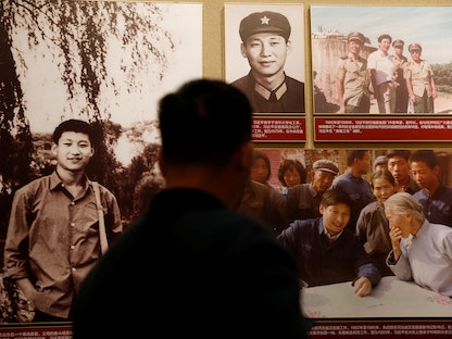 زائر يتأمل صوراً للرئيس الصيني شي جين بينج في متحف الحزب الشيوعي ببكين، 11 نوفمبر 2021 - REUTERS