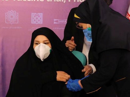 ممرضة تستعد لحقن متطوعة مشاركة في تجارب لقاح فيروس كورونا الإيراني، طهران، 29 ديسمبر 2020 - REUTERS