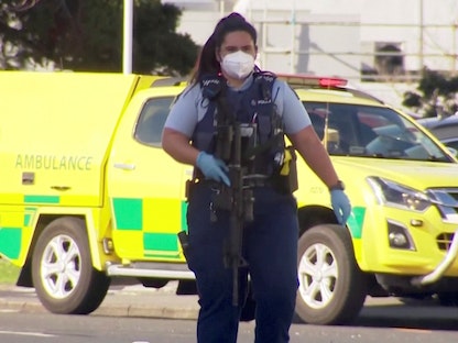 لقطة شاشة تظهر ضابط شرطة يسير بمسدس خارج مركز تسوق بعد هجوم بسكين في أوكلاند ، نيوزيلندا - 3 أغسطس 2021. -  REUTERS