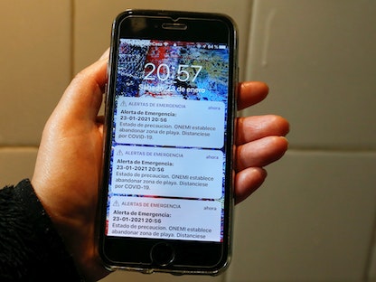 رسالة تحذير من حدوث تسونامي أرسلها مكتب الطوارئ الوطني في تشيلي عن طريق الخطأ على شاشة هاتف محمول - REUTERS