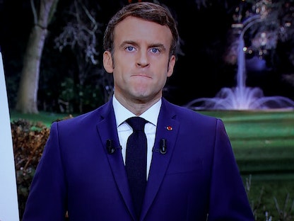 الرئيس الفرنسي إيمانويل ماكرون يظهر على الشاشة خلال خطابه بمناسبة العام الجديد في قصر الإليزيه، باريس، 31 ديسمبر 2021.  - REUTERS