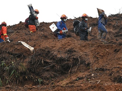 عمال الإنقاذ يمشطون الموقع الذي تحطمت فيه الطائرة الصينية في 21 مارس، بالقرب من ووتشو في مقاطعة قوانجشي جنوب غرب الصين - AFP