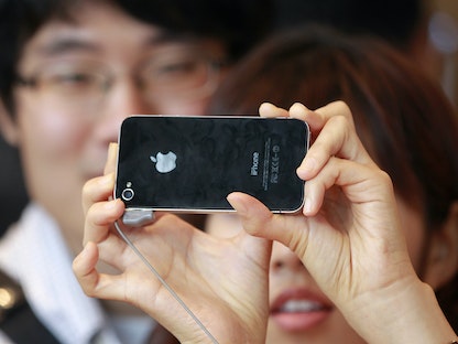 شخص يختبر كاميرا أحد هواتف لدى إطلاقه في أحد متاجر شركة "أبل" في كوريا الجنوبية - REUTERS