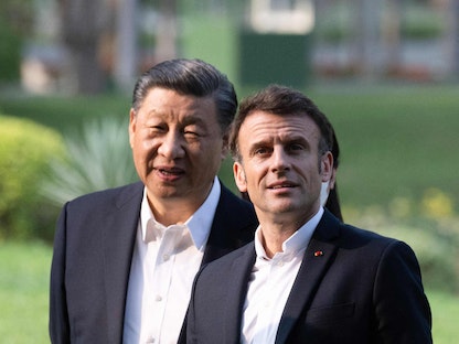 الرئيس الصيني شي جين بينج (يسار) ونظيره الفرنسي إيمانويل ماكرون (يمين) خلال زيارتهما لحديقة إقامة حاكم مقاطعة جوانزو حيث عاش والد شي. 7 أبريل 2023 - AFP