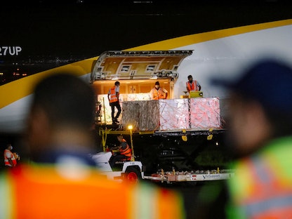 عمال يفرغون شحنات من لقاح كورونا تبرعت بها الولايات المتحدة لسلفادور ضمن مبادرة "كوفاكس"- 4 يوليو 2021 - Via REUTERS