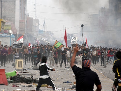 جانب من الاشتباكات بين متظاهرين مناهضين للحكومة وأنصار رجل الدين مقتدى الصدر في الناصرية - 28 نوفمبر 2020 - REUTERS
