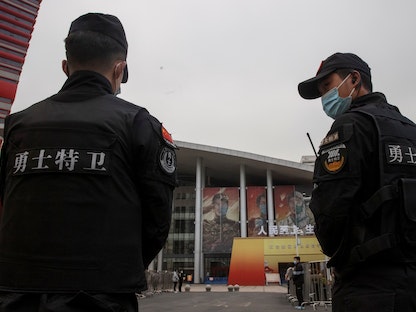 عنصران من الأمن الصيني في محيط زيارة فريق منظمة الصحة العالمية لأحد المواقع في مدينة ووهان، الصين - REUTERS