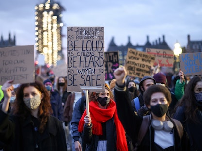 نساء على جسر ويستمنستر في العاصمة البريطانية لندن، يحملن لافتات أثناء الاحتجاج على اختطاف وقتل سارة إيفيرارد على يد شرطي. 15 مارس 2021 - REUTERS