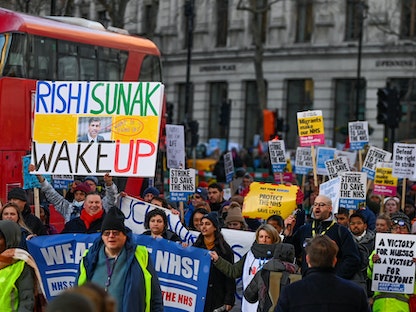 أشخاص يحملون لافتات أثناء إضراب ممرضات وغيرهم من العاملين الطبيين في لندن، بريطانيا - 18 يناير 2023 - REUTERS