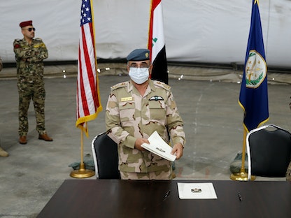 الجنرال الأميركي كينيث إيكمان، بجوار العميد صلاح عبد الله خلال مراسم تسليم قاعدة التاجي العسكرية من قوات التحالف بقيادة الولايات المتحدة إلى قوات الأمن العراقية، في قاعدة شمال بغداد، 23 أغسطس 2020  - REUTERS